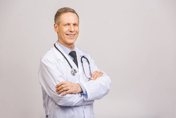 Portrait of happy senior man doctor smiling with arms crossed isolated over grey background.  - Фото, зображення