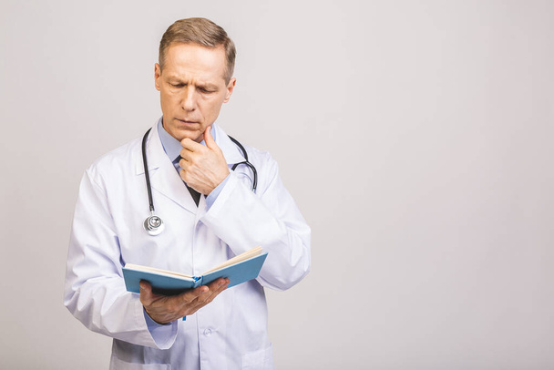 Senior doctor reading a book isolated over grey background. - Photo, Image