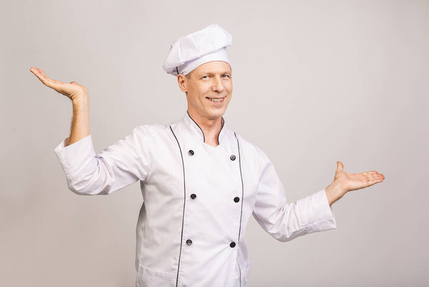 Senior cook man isolated showing a copy space on a palm. - Foto, Imagem