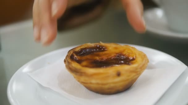 hand takes apate de Nata close-up - traditional Portuguese dessert on platter slow motion - Filmati, video