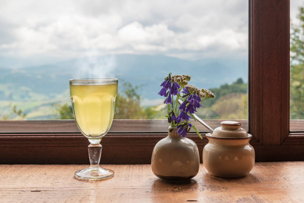 Cup of hot spicy tea or mulled wine and rainy weather behind the window. Mountain cafe - Фото, зображення