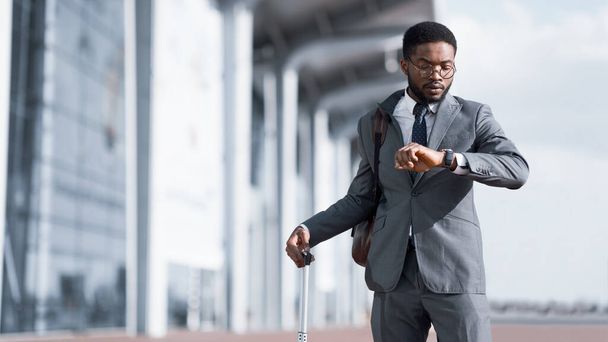Podnikatel Kontrola času při pohledu na náramkové hodinky stojící na letišti, Panorama - Fotografie, Obrázek