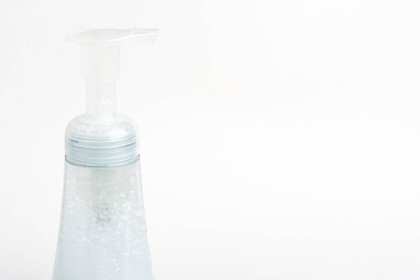 白い背景に発泡石鹸プラスチックディスペンサーの半透明のトップポンプとボトルのクローズアップ画像。. - 写真・画像