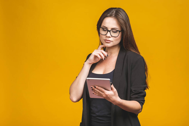 Business γυναίκα εκμετάλλευση tablet υπολογιστή απομονώνονται σε κίτρινο φόντο. - Φωτογραφία, εικόνα