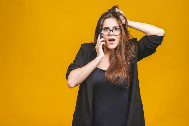 Porträt einer glücklichen, erstaunten Frau im smarten lockeren Telefongespräch auf gelbem Hintergrund. - Foto, Bild