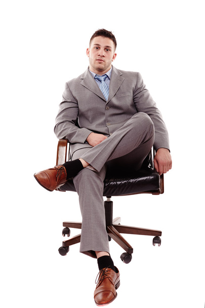 Confident businessman sitting on chair - Fotó, kép