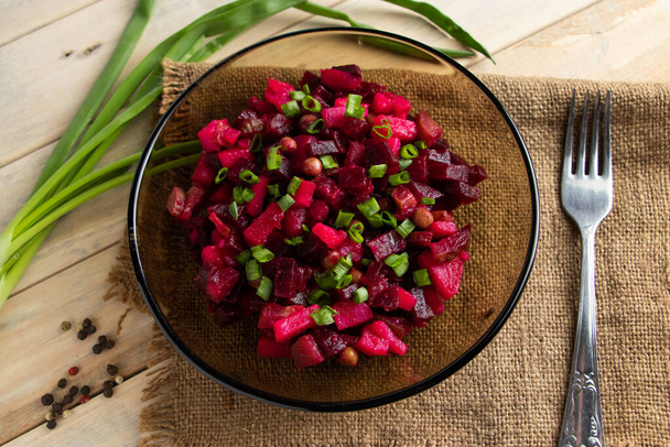 Vinaigrette sur un fond en bois. Salade de légumes russes avec betteraves rouges dans un bol. Style rustique, plat traditionnel
. - Photo, image