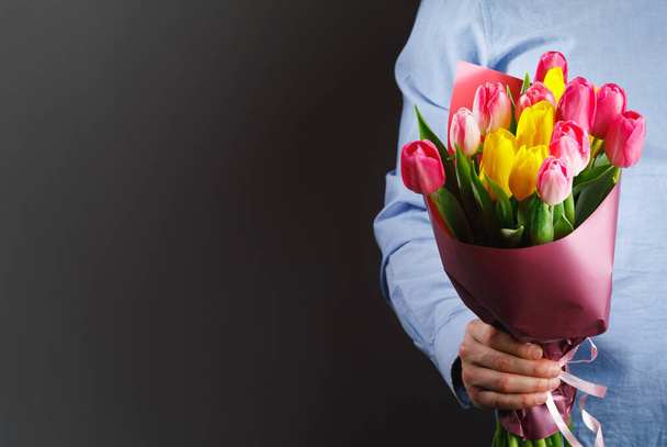 bouquet di fiori di tulipano in mano, sfondo grigio con copia-spazio
 - Foto, immagini