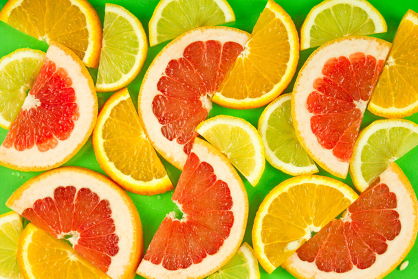 fondo de fruta, una mezcla de rodajas de cítricos, un conjunto de vitaminas de frutas, productos naturales saludables. Naranja madura jugosa, limón y pomelo
. - Foto, Imagen