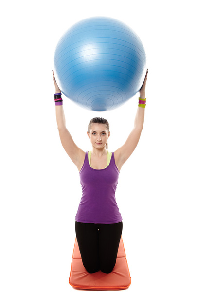 Athletic woman holding a ball and doing stretching - Foto, Imagem