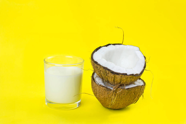 coconut and coconut milk on a yellow background. tropical natural ecological organic product and drink. ingredient for cocktails and dishes. - Photo, Image
