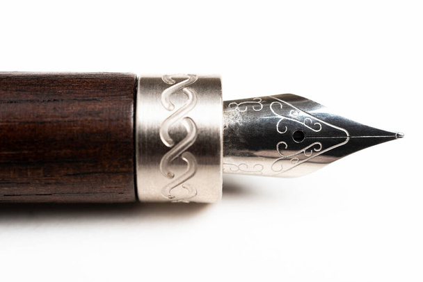 Um close-up produto tiro do barril de madeira e escrita ponta de uma caneta-tinteiro clássico definido no fundo branco liso
. - Foto, Imagem