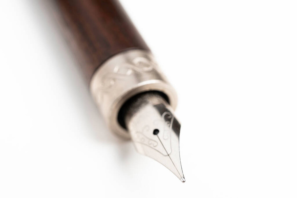 Un primo piano colpo di prodotto della canna di legno e la punta di scrittura di una penna stilografica classica impostata su sfondo bianco chiaro
. - Foto, immagini