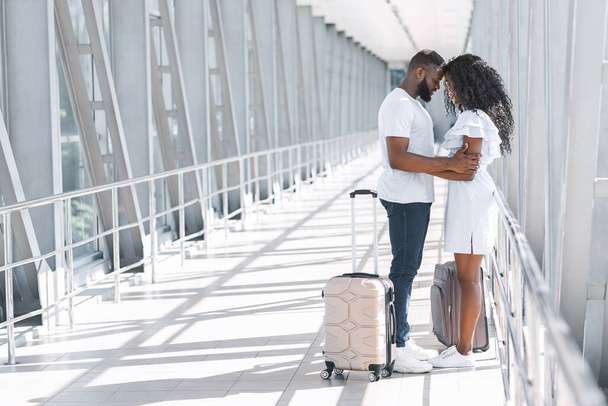 Treffen nach der Quarantäne. Romantisches Paar umarmt sich im Flughafen-Terminal - Foto, Bild