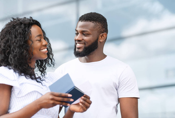 Retrato de feliz pareja negra con pasaportes y entradas en las manos
 - Foto, imagen