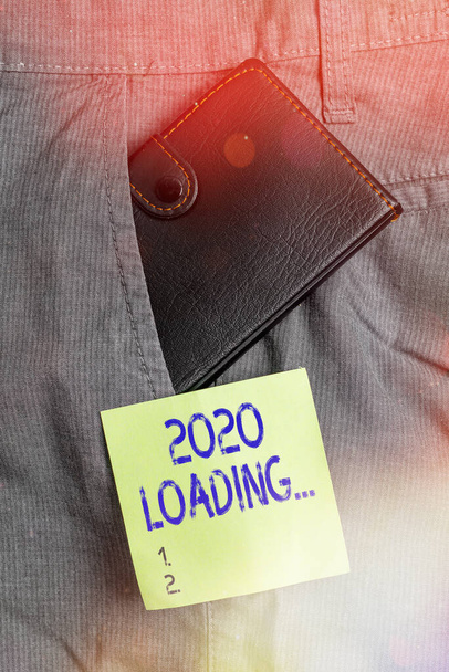 Writing note showing 2020 Loading.... Business photo showcasing a year composed of a series of events that are still going Small wallet inside trouser μπροστινή τσέπη κοντά σε χαρτί σημειώσεων. - Φωτογραφία, εικόνα