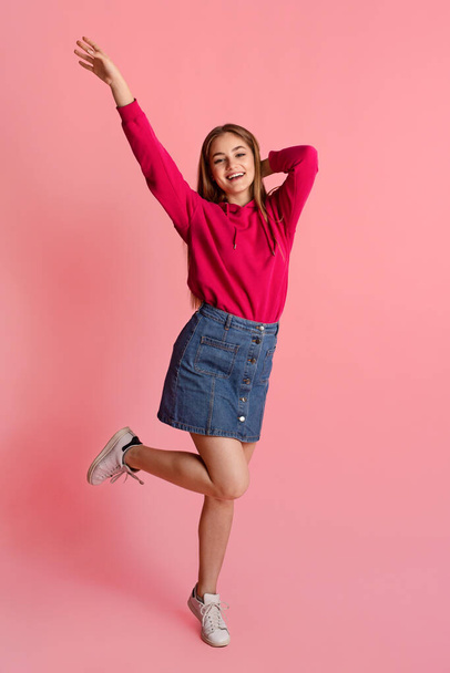 Glücklicher Teenager. Lächelndes Mädchen in lässiger Kleidung hüpft und tanzt - Foto, Bild