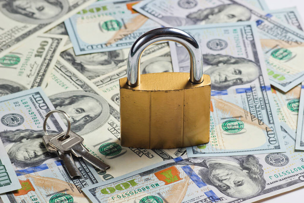 Golden lock with key on background of dollar bills - Фото, зображення