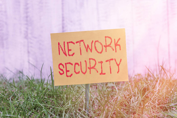 Writing note showing Network Security. Business photo showcasing practice of securing a computer web from intruders Plain paper attached to stick and placed in the grassy land. - Photo, Image