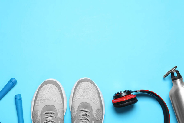 Flat lay composition with man's sneakers and fitness items on light blue background, space for text - Photo, Image