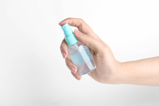 Woman holding antiseptic spray on white background, closeup - Foto, Imagem