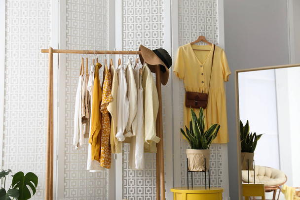 Rack with stylish women's clothes and mirror indoors. Interior design - Φωτογραφία, εικόνα