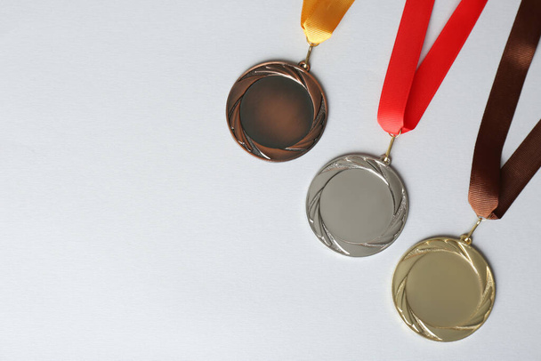 Gold, silver and bronze medals on white background, flat lay. Space for design - Photo, Image