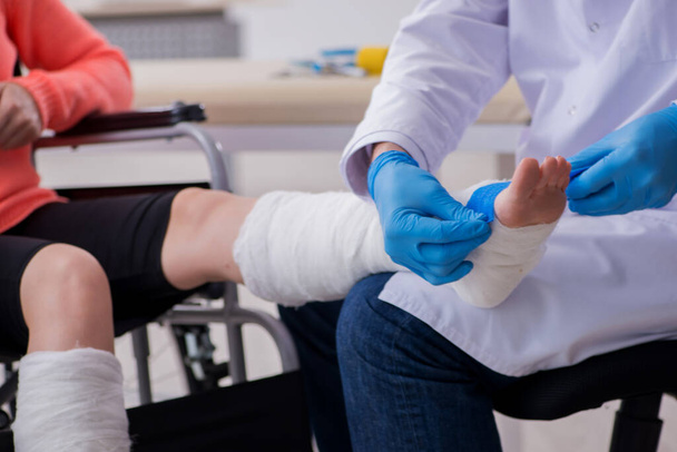 Νεαρή τραυματισμένη στο πόδι γυναίκα που επισκέπτεται γιατρό τραυματολόγο - Φωτογραφία, εικόνα