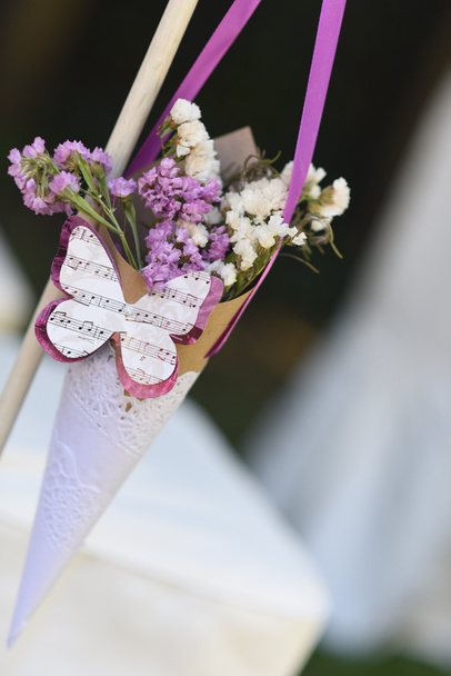 Cornet with dried flowers and butterfly with musical notes, decoration at the wedding ceremony - Photo, Image