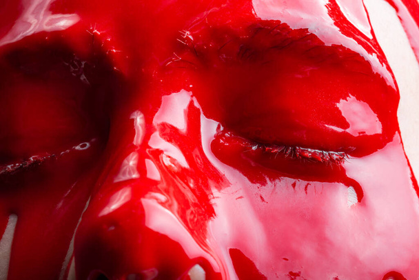 Immagine di un volto femminile con la diffusione di vernice rossa lucida
 - Foto, immagini