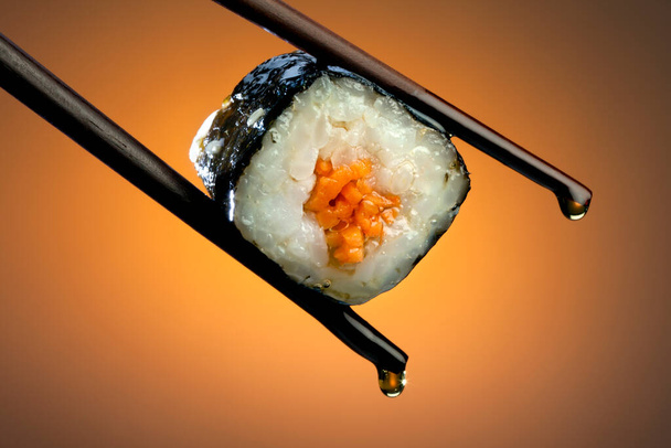 Суши - японское блюдо, состоящее из маленьких шариков или рулонов холодного риса со вкусом уксуса, подаваемого с гарниром из овощей, яиц или сырых морепродуктов
. - Фото, изображение