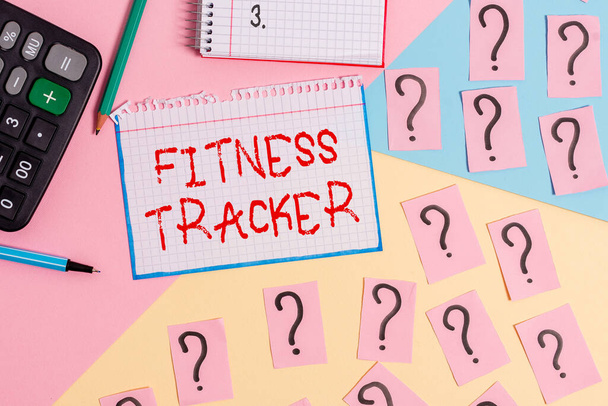 Kirjoitan Fitness Trackeria. Business valokuva esittelee valvontalaite, joka tallentaa mitään terveyteen liittyvää toimintaa Matematiikka juttuja ja kirjoituslaitteet edellä pastellivärit tausta. - Valokuva, kuva