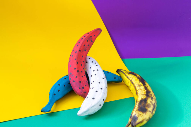 colored bananas on orange, blue cardboard - Φωτογραφία, εικόνα