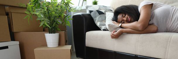 Κουρασμένος ετοιμάζεται να κινηθεί, γυναίκα κοιμάται στον καναπέ. - Φωτογραφία, εικόνα