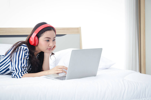 Asyalı kadınlar evden çalışır uyur, rahatlar, film izler, müzik dinlerler. - Fotoğraf, Görsel