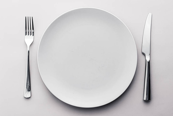 Empty plate and cutlery as mockup set on white background, top tableware for chef table decor and menu branding - Φωτογραφία, εικόνα