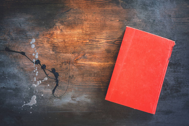 Old red book on dark wooden flat lay background with copy space. - Fotografie, Obrázek