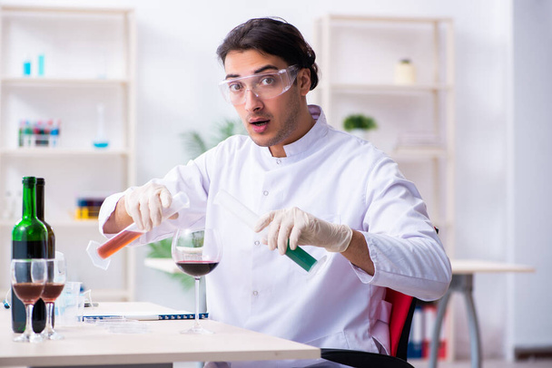 Mužský chemik vyšetřuje vzorky vína v laboratoři - Fotografie, Obrázek
