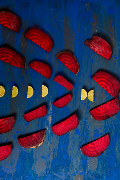 Barbabietola nella forma di un modello con fette di limone su uno sfondo viola
 - Foto, immagini