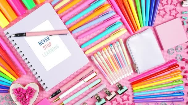 Vissza az iskolába vagy a munkahelyre színes írószer fölött rózsaszín lapos. - Felvétel, videó