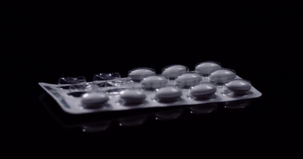 Blister de medicamentos píldoras médicas sobre fondo negro  - Imágenes, Vídeo