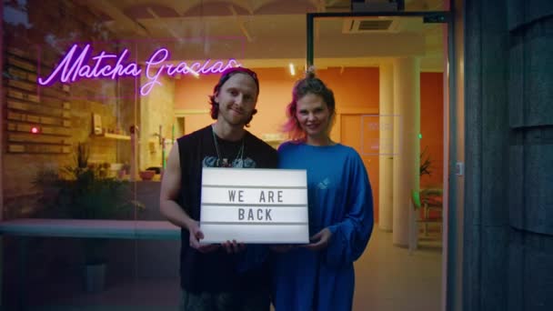 Couple of small business owners invites customers - Materiał filmowy, wideo