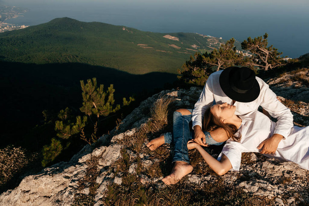 Attractive young loving couple of man and woman in the green mountain landscape - Foto, afbeelding