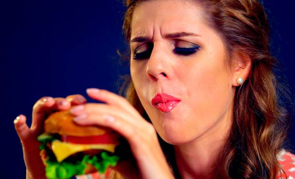 Menina em lugares de comida come hambúrguer
 - Foto, Imagem