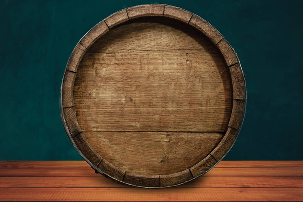 Beautiful wooden barrel on a red wood table and green  wall background.	 - Photo, Image