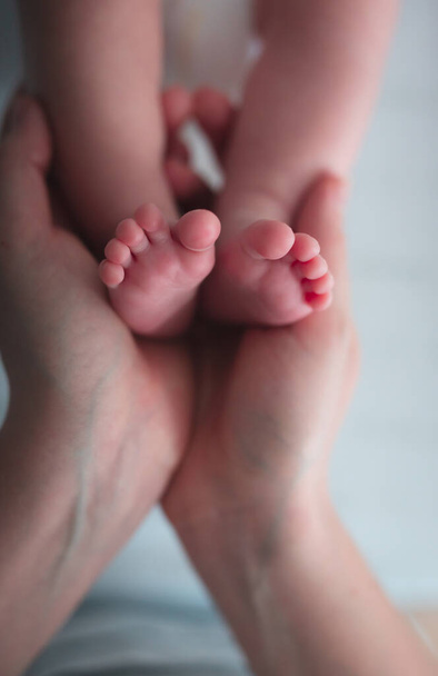 コピースペースで赤ちゃんの足を閉じ保持女性の手 - 写真・画像
