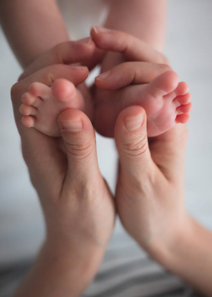 Donna mani tenendo i piedi del bambino primo piano con spazio copia
 - Foto, immagini