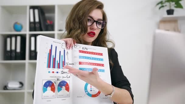 Front view of adorable confident 30-aged bright businesswoman with nice look which explaining financial charts to her business partner via video call in her office room - Felvétel, videó