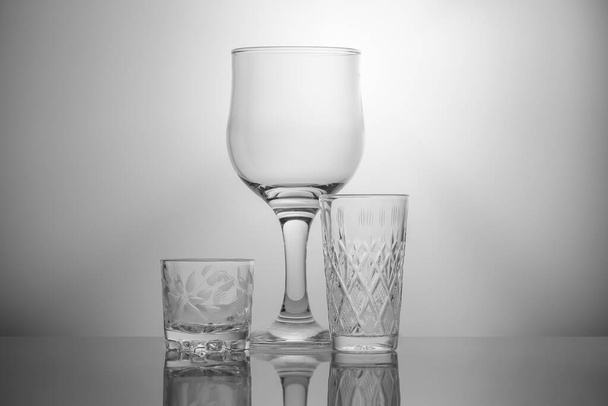 Copo de vinho de vidro e copos de cristal em um fundo branco
 - Foto, Imagem