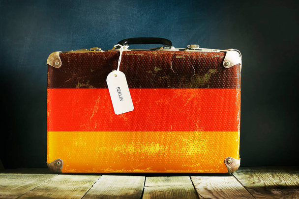 Старый чемодан с флагом Германии на деревянном фоне. Путешествия
. - Фото, изображение